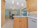 Open kitchen with light wood cabinets, tile flooring, and dining area beyond at 309 South Dr, Nokomis, FL 34275