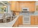 Charming kitchen with updated marble countertops, stainless sink, and wood cabinetry at 309 South Dr, Nokomis, FL 34275