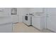 Functional laundry room with white washer, dryer, cabinets and tiled floor at 309 South Dr, Nokomis, FL 34275