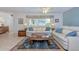 Bright living room with white couches, a ceiling fan, a decorative rug, and natural light through a window at 309 South Dr, Nokomis, FL 34275