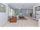 Open-concept living room with tile floors, comfortable seating, and a view of the dining area at 309 South Dr, Nokomis, FL 34275