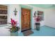Inviting front door featuring a rich wood finish, decorative lanterns, and lush potted plants, enhancing curb appeal at 3445 Anglin Dr, Sarasota, FL 34242