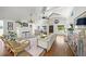 Spacious living room with vaulted ceilings, a brick fireplace, hardwood floors, stylish furniture, and natural lighting at 3445 Anglin Dr, Sarasota, FL 34242