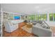 Comfortable living room with terracotta floors, built-in shelving, and a cozy seating arrangement and green shutters at 3445 Anglin Dr, Sarasota, FL 34242