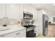 Bright white kitchen featuring stainless steel appliances and a stylish backsplash at 355 N Washington Dr, Sarasota, FL 34236