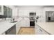 Modern white kitchen with stainless steel appliances and quartz countertops at 355 N Washington Dr, Sarasota, FL 34236