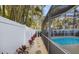 Inviting pool area with a screened enclosure, lush landscaping, and a walkway at 355 N Washington Dr, Sarasota, FL 34236