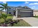 Two-story house with gray siding, stone accents, and a two-car garage at 509 Powder View Dr, Ruskin, FL 33570