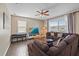Living room featuring a brown sectional sofa, a TV, and large windows at 509 Powder View Dr, Ruskin, FL 33570