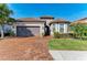 One-story home with brown tile roof, gray garage door, and landscaped yard at 5406 Morey Farms Loop, Palmetto, FL 34221