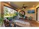 Screened porch with seating area, large art piece and TV at 5406 Morey Farms Loop, Palmetto, FL 34221