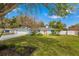 Light blue house with coral door, landscaped yard, and a large tree at 6926 Magellan Way, Sarasota, FL 34243