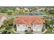 Aerial view of homes with tile roofs, a pond, and lush green surroundings in a serene community at 7254 Cedar Hollow Cir, Bradenton, FL 34203