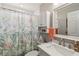 Bright bathroom with a vanity, white cabinets, and a shower with a tropical-themed curtain at 7254 Cedar Hollow Cir, Bradenton, FL 34203
