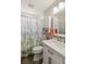 Bright bathroom with a vanity, white cabinets, and a shower with a tropical-themed curtain at 7254 Cedar Hollow Cir, Bradenton, FL 34203