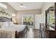 Bedroom with view, ceiling fan, wood-look floors, and a large window at 7254 Cedar Hollow Cir, Bradenton, FL 34203