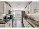 Galley kitchen featuring white cabinetry, stone countertops and stainless steel appliances at 7254 Cedar Hollow Cir, Bradenton, FL 34203