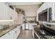 Open-concept kitchen with white cabinetry, stone countertops, and stainless steel appliances at 7254 Cedar Hollow Cir, Bradenton, FL 34203