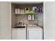Convenient laundry room featuring a washer and dryer with storage shelves at 7254 Cedar Hollow Cir, Bradenton, FL 34203