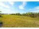 Landscaped backyard with pond view and grassy lawn area at 8066 Redonda Loop, Bradenton, FL 34202