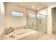 Elegant bathroom with a large soaking tub, glass shower, and marble tile at 8066 Redonda Loop, Bradenton, FL 34202
