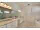 Double vanity bathroom with marble floors and a large mirror at 8066 Redonda Loop, Bradenton, FL 34202