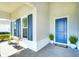 Inviting front porch with blue door, shutters, and a tiled floor at 8066 Redonda Loop, Bradenton, FL 34202