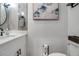 Clean bathroom, featuring a white vanity, a round mirror, and fish artwork at 821 Evergreen Way, Longboat Key, FL 34228