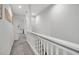 Upstairs hallway with carpet flooring, white railing, and access to laundry room at 821 Evergreen Way, Longboat Key, FL 34228