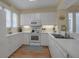 Efficient kitchen with white cabinets, full-size appliances, and double sink at 821 Evergreen Way, Longboat Key, FL 34228