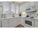 White kitchen with ample counter space and a window overlooking the neighborhood at 821 Evergreen Way, Longboat Key, FL 34228