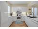 Well-equipped kitchen featuring white cabinets, modern appliances and ample counter space at 821 Evergreen Way, Longboat Key, FL 34228