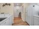 Kitchen with white appliances, wood-look floors, and access to the hallway at 821 Evergreen Way, Longboat Key, FL 34228