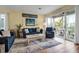 Living room with blue sofas, a coffee table, and access to a balcony at 821 Evergreen Way, Longboat Key, FL 34228
