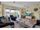 Bright living room with comfy seating, large TV, and sliding glass doors leading to balcony at 821 Evergreen Way, Longboat Key, FL 34228
