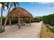 Thatch palapa and picnic table near a pathway at 821 Evergreen Way, Longboat Key, FL 34228