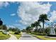 Landscaped entrance to community with palm trees and walking path at 8612 Sundance Loop, Sarasota, FL 34238