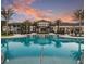 Resort-style pool with clubhouse at sunset, lush landscaping at 8612 Sundance Loop, Sarasota, FL 34238