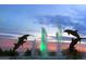 Silhouetted dolphins leap over a vibrant water fountain at sunset at 8612 Sundance Loop, Sarasota, FL 34238