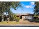 Single-story home with stone accents and a two-car garage, nestled among lush landscaping at 917 S Doral Ln, Venice, FL 34293