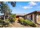 House entrance with a walkway, featuring landscaping and a unique orange door at 917 S Doral Ln, Venice, FL 34293