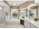 Bright bathroom with large soaking tub, dual sinks, vanity, and a separate glass shower for a spa-like experience at 958 Chickadee Dr, Venice, FL 34285