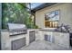 Stainless steel outdoor kitchen with built-in grill and refrigerator at 1027 Kestrel Ct, Bradenton, FL 34208