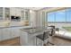 Bright white kitchen with island seating, stainless steel appliances, and water views at 10510 Boardwalk Loop # 602, Bradenton, FL 34202