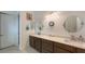 Bathroom with double vanity, oval mirrors, and dark brown cabinets at 12607 Wheatgrass Ct, Parrish, FL 34219