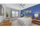 Main bedroom with blue accent wall, a large window and ensuite bathroom at 12607 Wheatgrass Ct, Parrish, FL 34219