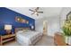 Main bedroom with blue accent wall, wooden bed frame and ensuite bathroom at 12607 Wheatgrass Ct, Parrish, FL 34219