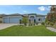 Beautiful light blue house with a 3-car garage and nicely landscaped front yard at 12607 Wheatgrass Ct, Parrish, FL 34219