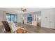 Spacious living room with hardwood floors, a large TV, and access to a patio at 12607 Wheatgrass Ct, Parrish, FL 34219