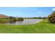 Peaceful pond view with grassy banks and homes in background at 12607 Wheatgrass Ct, Parrish, FL 34219